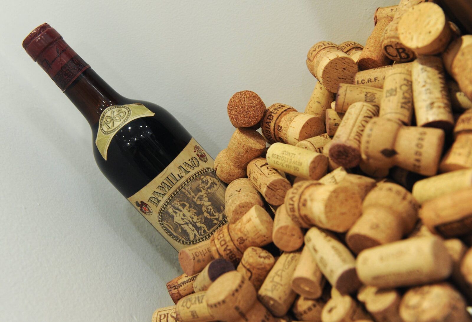 Bottiglia di vino d’annata accanto a una collezione di tappi